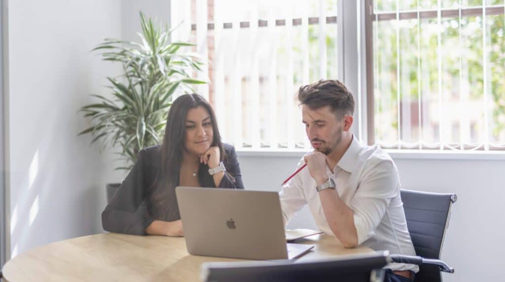 People working on a laptop looking at group reorganisations