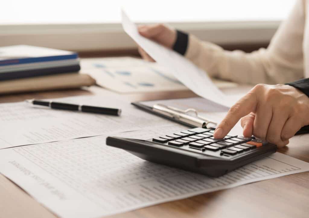 Picture of a person looking at paper work and using a calculator