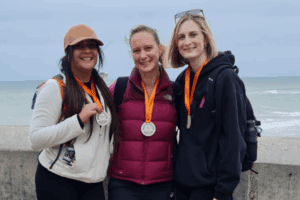 From left to right: Melissa Porter, Ali Robinson, and Helen Hunt from GLX post with their medals after having completed the Norfolk Coastal Walk.