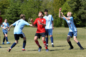 Photos of 4 players for the Thorpe St Andrew Leopards Under-15s team wearing blue GLX sponsored shirts and playing football with one member of the opposition in the frame wearing a red shirt.