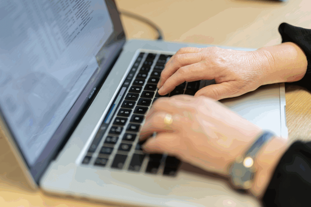 Photo for the Insurance Polices for Directors post showing two hands using a laptop keyboard.