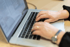 Photo for the Insurance Polices for Directors post showing two hands using a laptop keyboard.
